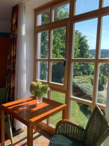 einen Tisch und Stühle vor einem großen Fenster in der Unterkunft Ferienappartement mit Panoramablick in Rötz