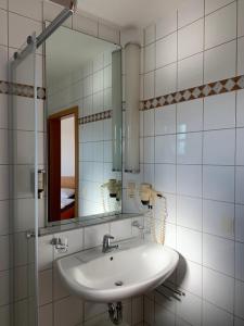 a white bathroom with a sink and a mirror at Ferienappartement mit Panoramablick in Rötz