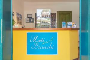 um balcão amarelo e azul com um cartaz em Residence I Mirti Bianchi em Santa Teresa Gallura