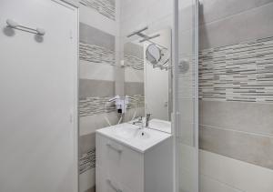 Un baño blanco con lavabo y ducha. en Fauriel Aimé, en Saint-Étienne 4 fotos más