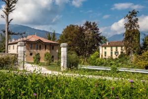 une maison ancienne avec un jardin en face dans l'établissement Casa Guarnieri, à Feltre