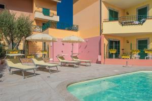 ośrodek z basenem, krzesłami i budynkiem w obiekcie Residence I Mirti Bianchi w mieście Santa Teresa Gallura