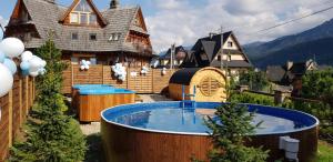 a backyard with a hot tub and a house at Villa Delta Boutique in Kościelisko