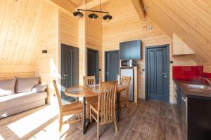 a kitchen and dining room with a table and chairs at Chalets Na'Thur lodge in Fellering