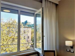 a room with a large window with a view at Hotel Lidò in Passignano sul Trasimeno