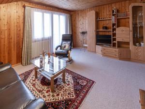 ein Wohnzimmer mit einem Sofa, einem Stuhl und einem Tisch in der Unterkunft Ferienwohnung & Studio Schaad in Hasliberg Wasserwendi