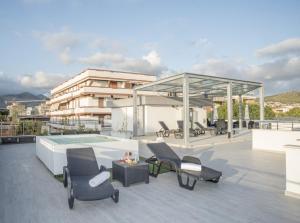 - une terrasse avec des chaises et une piscine dans un bâtiment dans l'établissement Acca residence, à Terracine