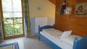 um quarto com uma cama azul e uma janela em Ferienhaus Drexler em Neukirchen beim Heiligen Blut