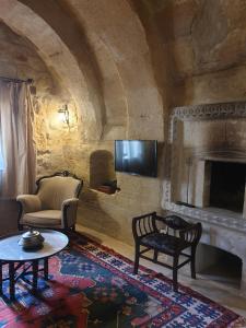 a living room with a fireplace and a tv at Aydinli Cave Hotel in Göreme