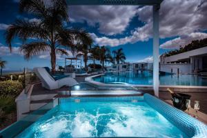 uma piscina num resort com palmeiras em White Luxury Villa em Hersonissos