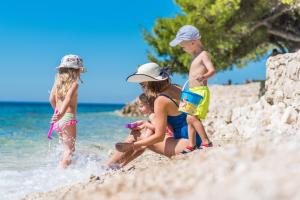 a group of children playing on the beach at Hotel Pinija in Petrcane