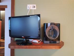 a television sitting on a wooden shelf with a speaker at Casa de Pueblo en Saillagousse ideal familias in Saillagouse