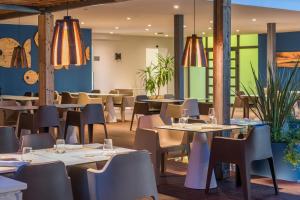 a dining room with tables and chairs and tablesktop at Hotel Pinija in Petrcane