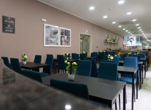 a dining room with blue chairs and tables at Residencial do Areeiro in Lisbon