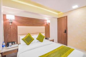 a bedroom with a large bed with a wooden headboard at Oxford Hotel Powai in Mumbai