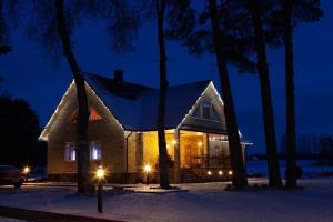 ein Haus mit Lichtern im Schnee in der Nacht in der Unterkunft Seedri Guesthouse in Võru