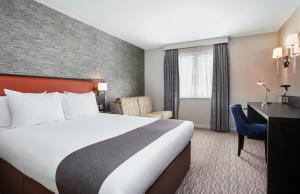 ein Hotelzimmer mit einem Bett und einem Schreibtisch in der Unterkunft Holiday Inn Belfast, an IHG Hotel in Belfast