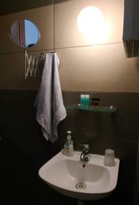 een badkamer met een witte wastafel en een spiegel bij manesi stone built studio in Manésion