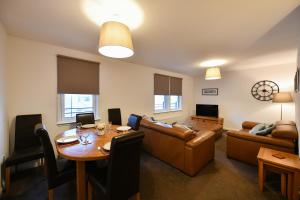 a living room with a table and a couch at Harbour Quay Apartment in Irvine