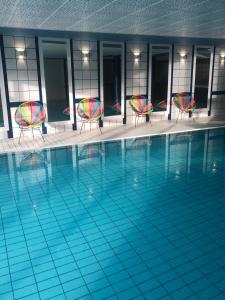 a swimming pool with two chairs and a pool at Hôtel Panorama in Munster