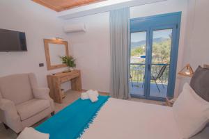 ein Schlafzimmer mit einem Bett, einem Stuhl und einem Fenster in der Unterkunft Akrotiri in Vasiliki