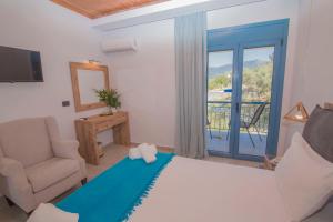 a bedroom with a bed and a chair and a window at Akrotiri in Vasiliki
