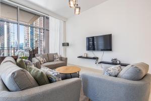 a living room with two couches and a tv at Gorgeous 2 BR mid floor Holiday Home in Downtown in Dubai