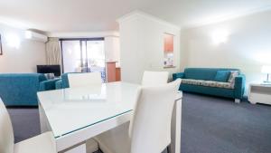 a living room with a white table and chairs at Burleigh on the Beach in Gold Coast