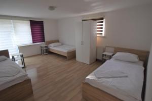 a bedroom with two beds and a room with a table at Apartment Ostfildern in Ostfildern