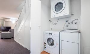 a laundry room with a washer and dryer at Burleigh on the Beach in Gold Coast