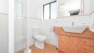 a bathroom with a toilet, sink, and tub at Burleigh on the Beach in Gold Coast