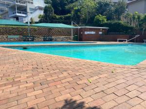 a swimming pool with blue water in a building at 106 Umdloti Resort in Umdloti