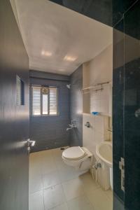 a bathroom with a toilet and a sink at Hotel Grand Ashwin in Nashik