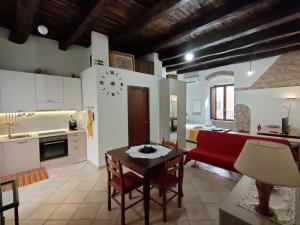 een keuken en een woonkamer met een tafel en een rode bank bij La Pietra Antica in Paola