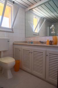 W łazience znajduje się umywalka, toaleta i lustro. w obiekcie Marina Apartment w mieście Quarteira