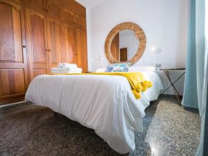 1 dormitorio con 1 cama con manta amarilla y espejo en Av.Dacio Darias 66, 1ºA Villa de valverde., en Valverde