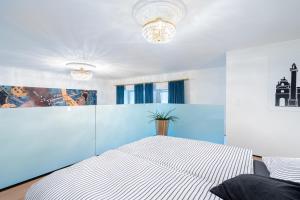 ein Schlafzimmer mit einem weißen Bett und einer blauen Wand in der Unterkunft The Music - Luxuriöses City Loft am Naschmarkt in Wien