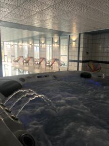 a hot tub with snow in a room with chairs at Hôtel Panorama in Munster