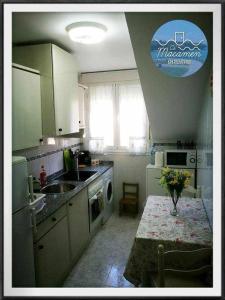 a kitchen with a table with a vase of flowers on it at Ca MaCaMen Tapia in Tapia de Casariego