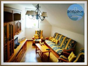 a living room with a couch and two chairs at Ca MaCaMen Tapia in Tapia de Casariego