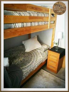 a bedroom with two bunk beds and a night stand at Cifuentes y López in Mieres