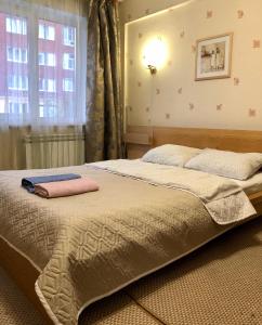 a bedroom with a bed with two pillows on it at Polet Hotel in Omsk