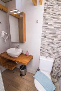 a bathroom with a white toilet and a sink at Grand TheoNi Boutique Hotel & Spa in Vasiliki