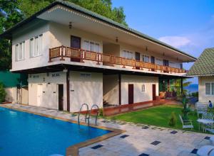 a house with a swimming pool in front of it at Cyrus Lake Haven in Alleppey