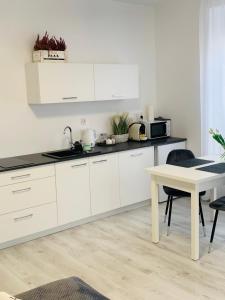 a kitchen with white cabinets and a table at Apartament Walczaka 22 MIEJSCE PARKINGOWE in Gorzów Wielkopolski