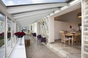 a living room with a conservatory with a table and chairs at Thirley Cotes Farm Cottages in Scarborough