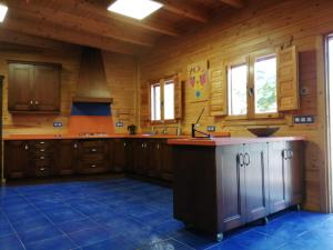 a large kitchen with wooden walls and wooden cabinets at Casa Rural Rio Chicamo in La Umbría