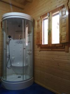 a shower in a wooden bathroom with a window at Casa Rural Rio Chicamo in La Umbría