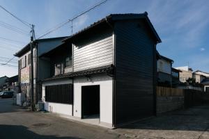 een zwart-wit gebouw met een garage bij B&B MIKAWA Info Centre - Kanazawa Fish Harbour in Kanazawa