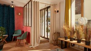 Hôtel Villa Sorel - Paris Boulogne في بولون بيانكور: غرفة معيشة مع طاولة وبعض النباتات